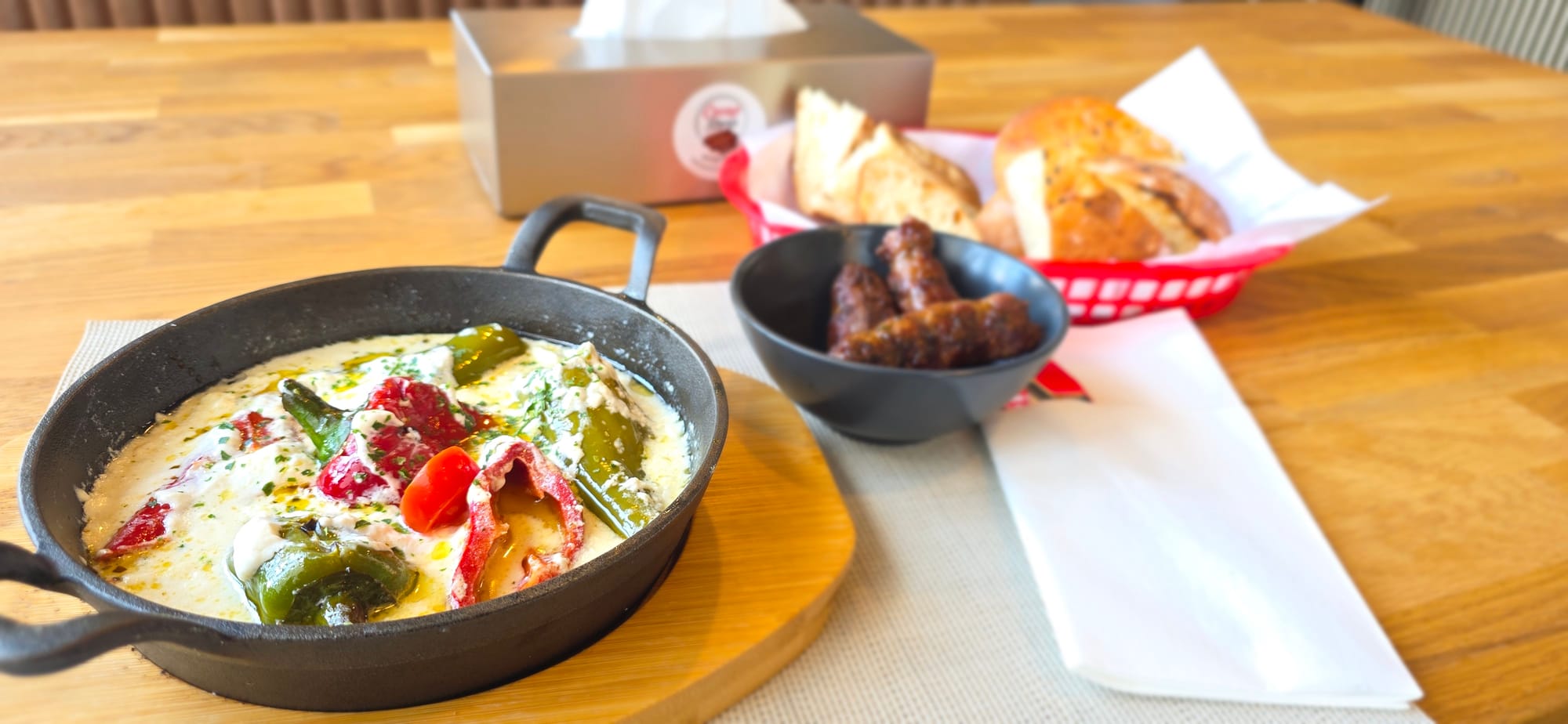 Des poivrons gratinés, des ćevapi et du pain au Cevap Store à Lausanne.