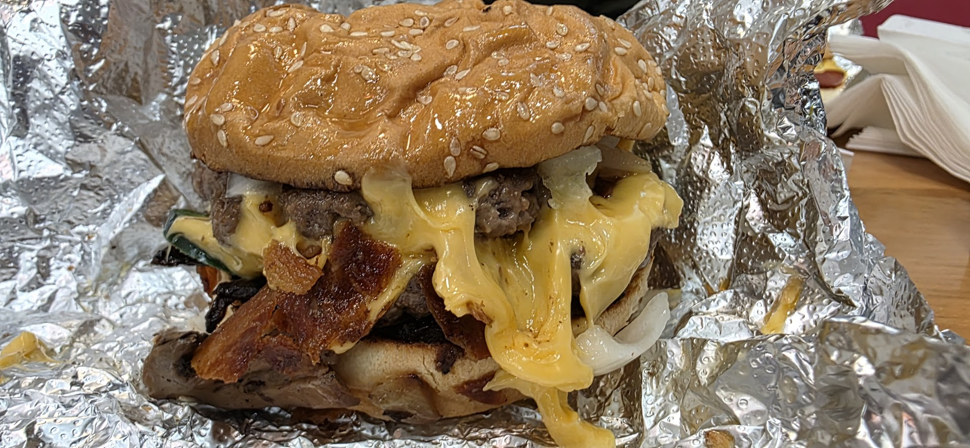 Un gros cheeseburger dégoulinant avec bacon, jalapeño et oignons chez Five Guys à Lausanne