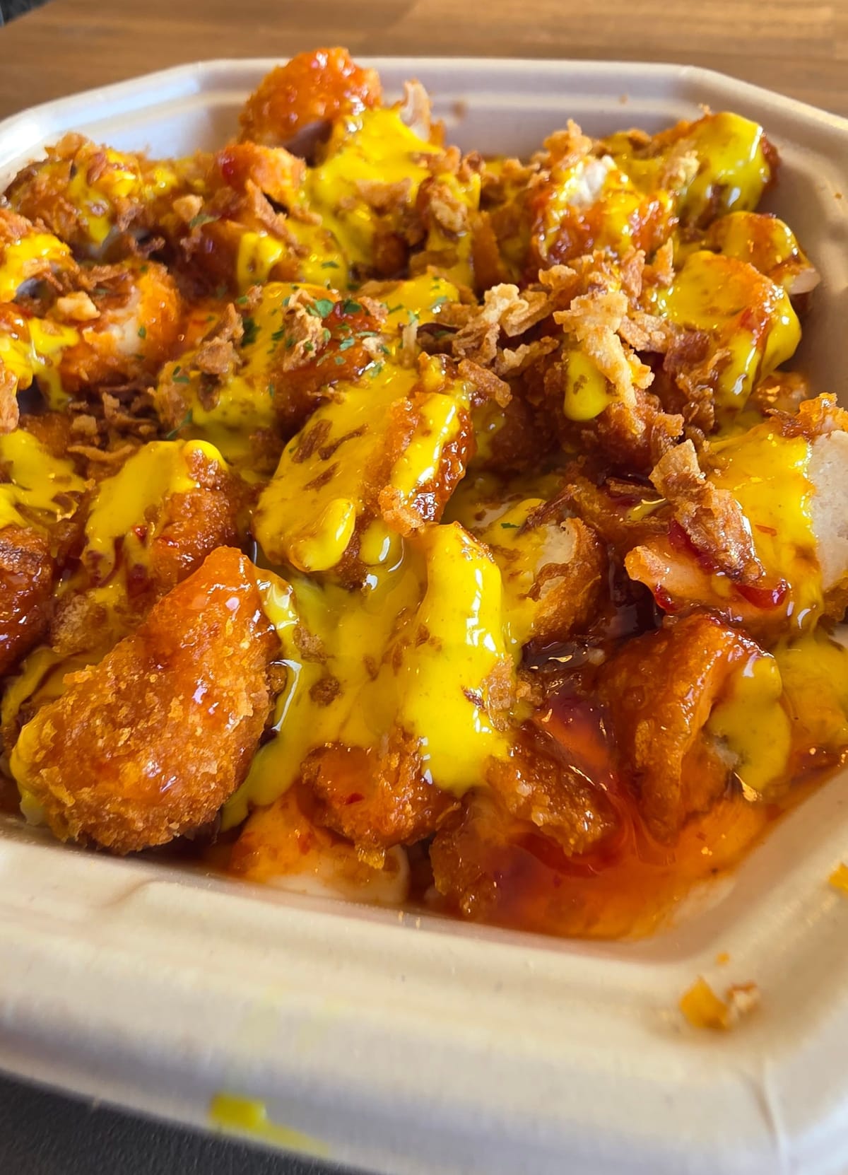 Gros plan d'un Crousty sauce curry et aigre-douce chez Tacodor à Lausanne. 